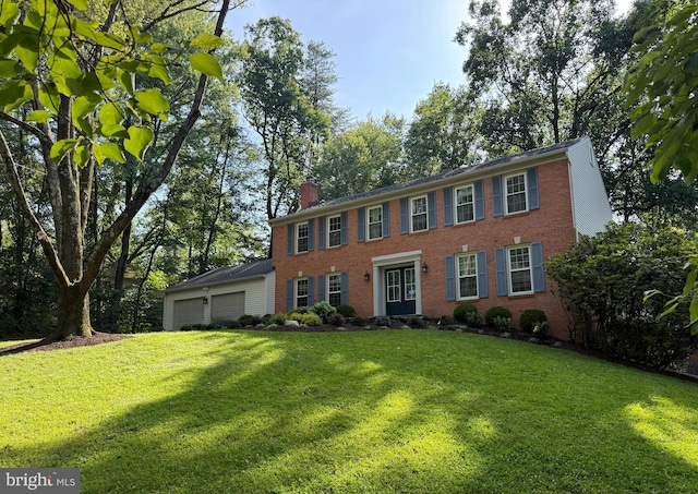 1448 Laurel Hill Rd, Vienna, VA 22182 - colonial home featuring a garage, a front lawn, brick siding, and a chimney