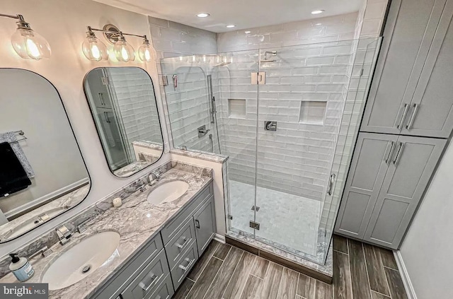 1448 Laurel Hill Rd, Vienna, VA 22182 - full bathroom featuring a shower stall, wood finish floors, double vanity, and recessed lighting
