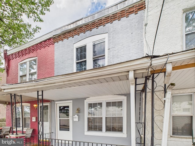 exterior space featuring a porch, stucco siding, and brick siding