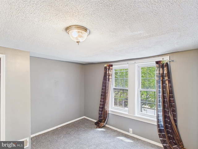 unfurnished room featuring carpet flooring, a textured ceiling, and baseboards
