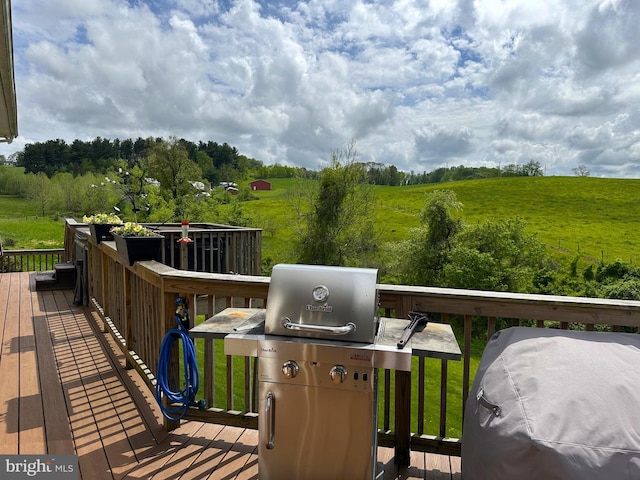 deck featuring area for grilling, a rural view, and a lawn