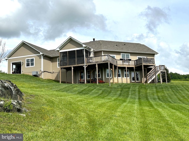 rear view of house with a sunroom, stairs, a wooden deck, and a lawn