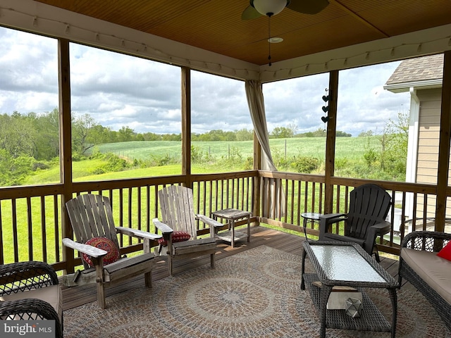 sunroom / solarium featuring a rural view and ceiling fan