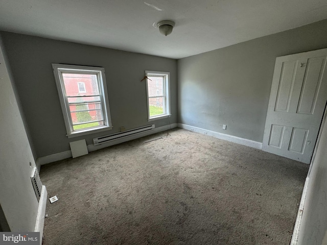 carpeted spare room with baseboards and a baseboard heating unit