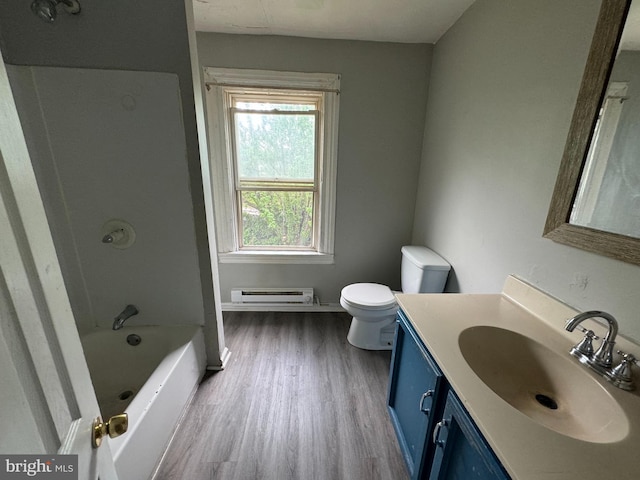 full bath with toilet, wood finished floors, vanity, baseboard heating, and tub / shower combination
