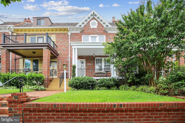 1362 Sheridan St NW, Washington, DC 20011 - view of front facade with a balcony, brick siding, a porch, and a front lawn