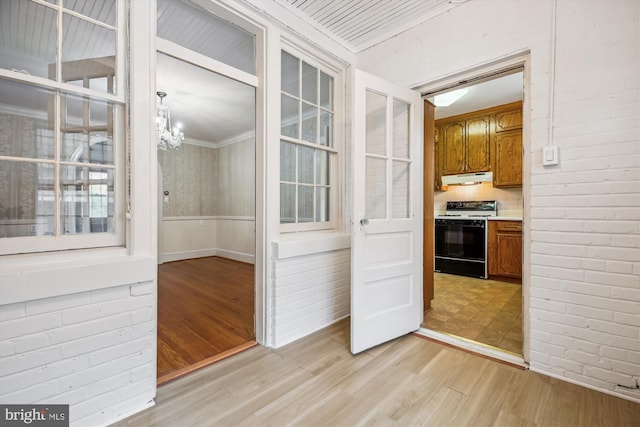 1362 Sheridan St NW, Washington, DC 20011 - interior space featuring light wood-style floors, a chandelier, crown molding, and brick wall