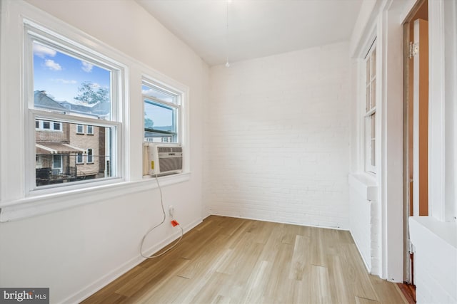 1362 Sheridan St NW, Washington, DC 20011 - spare room featuring brick wall, light wood finished floors, and cooling unit