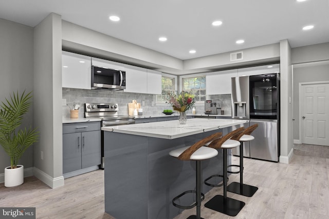 918 Andorra Rd, Lafayette Hill, PA 19444 - kitchen with stainless steel appliances, gray cabinets, a breakfast bar area, visible vents, and modern cabinets
