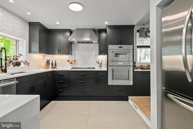 3175 21st St N, Arlington, VA 22201 - kitchen with light countertops, stainless steel appliances, tasteful backsplash, and wall chimney exhaust hood