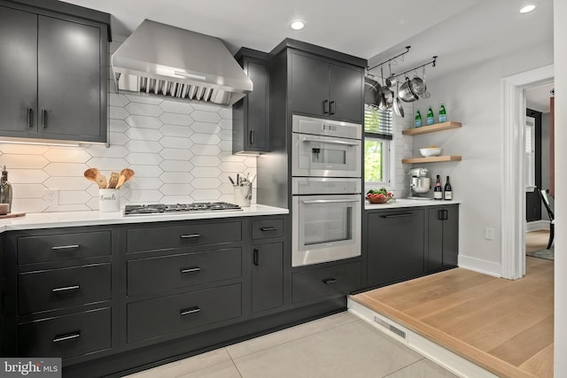 3175 21st St N, Arlington, VA 22201 - kitchen featuring double oven, wall chimney exhaust hood, light countertops, and stainless steel gas stovetop