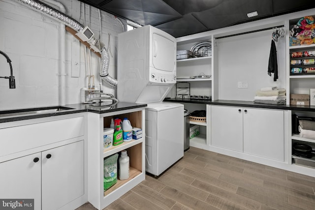3175 21st St N, Arlington, VA 22201 - laundry room with a sink, light wood-style flooring, stacked washer / drying machine, and cabinet space