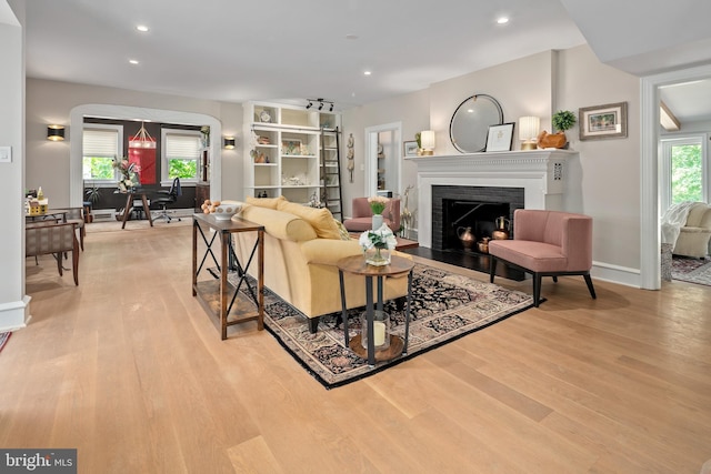 3175 21st St N, Arlington, VA 22201 - living room with recessed lighting, baseboards, light wood finished floors, arched walkways, and a fireplace