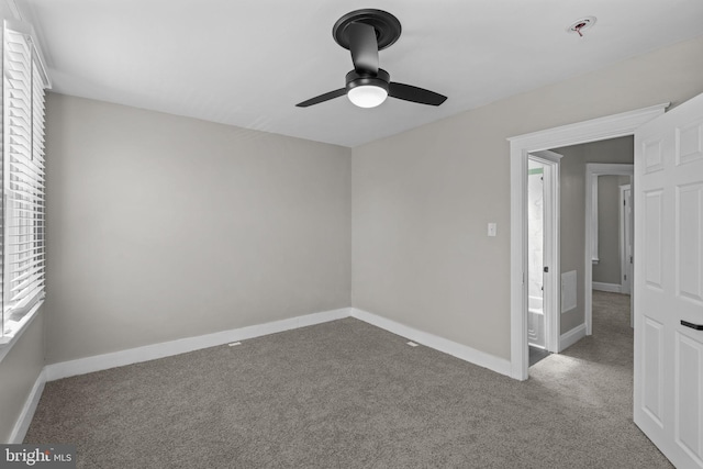 carpeted spare room featuring baseboards, ceiling fan, and a pendent fire sprinkler