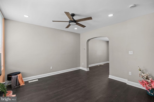 unfurnished room featuring arched walkways, ceiling fan, dark wood-style flooring, a smoke detector, and recessed lighting