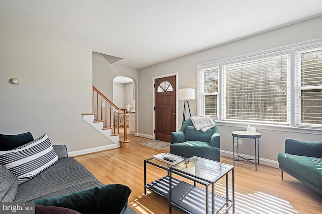 6226 Long Meadow Dr, Sykesville, MD 21784 - living area with arched walkways, healthy amount of natural light, wood finished floors, and stairs