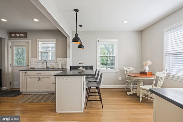 6226 Long Meadow Dr, Sykesville, MD 21784 - kitchen with a sink, dark countertops, light wood-style floors, plenty of natural light, and recessed lighting