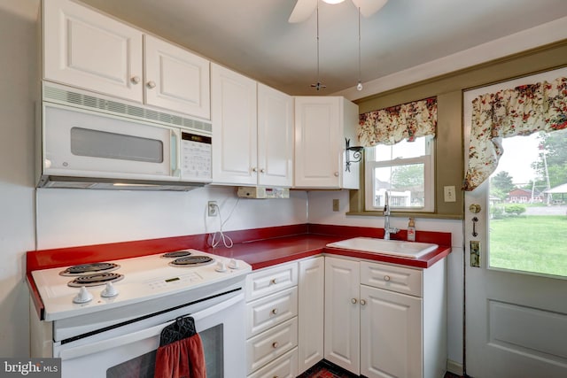 kitchen featuring white appliances, a sink, white cabinetry, and ceiling fan
