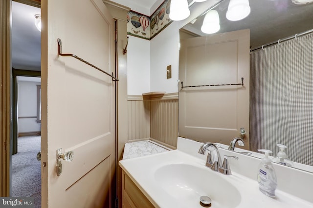 full bathroom featuring wainscoting and vanity