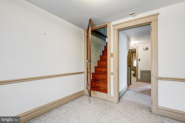 hallway with carpet floors and stairs