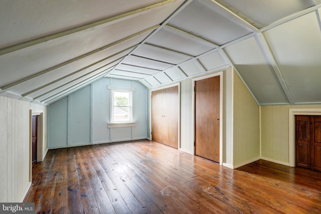additional living space with vaulted ceiling, hardwood / wood-style floors, and baseboards