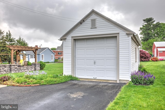 detached garage featuring asphalt driveway