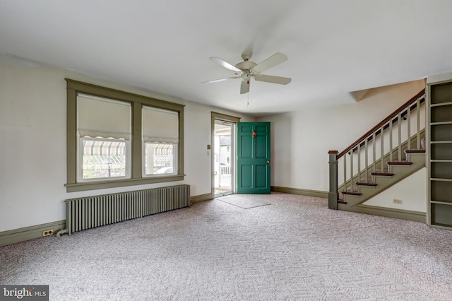 foyer entrance featuring radiator heating unit, healthy amount of natural light, carpet floors, and a ceiling fan
