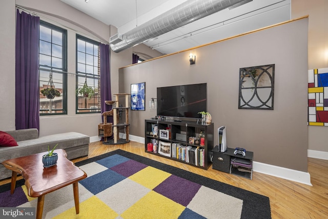 living area with baseboards and wood finished floors