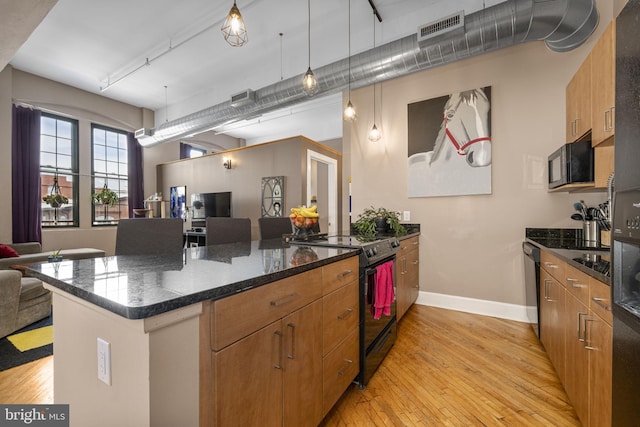 kitchen with visible vents, a peninsula, open floor plan, black appliances, and light wood-type flooring