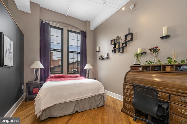 bedroom with baseboards and hardwood / wood-style flooring