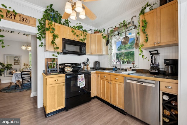 kitchen featuring black appliances, light wood-style floors, tile countertops, and crown molding
