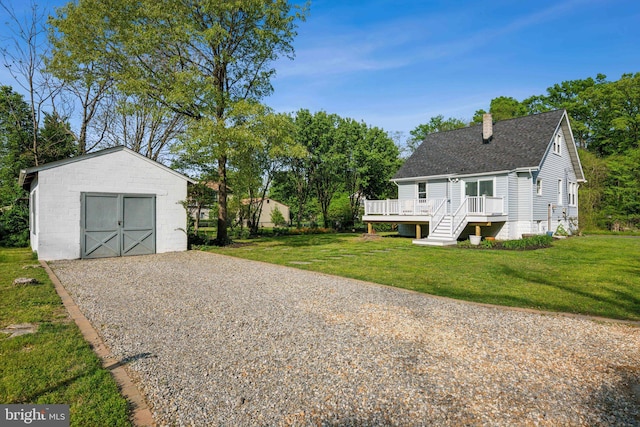 exterior space with an outbuilding, driveway, and a deck