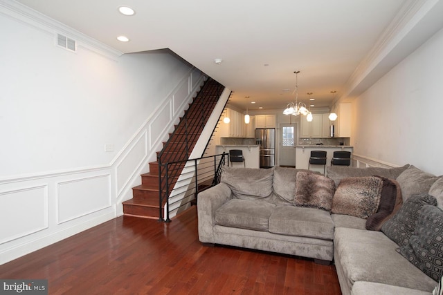 living area with a notable chandelier, stairway, crown molding, and visible vents
