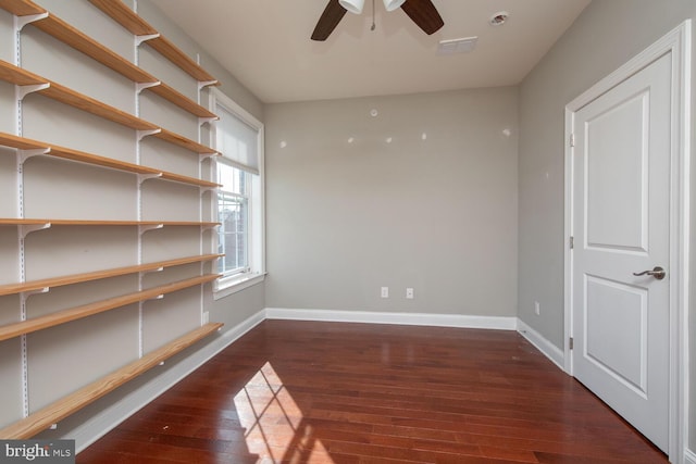 interior space with a ceiling fan, baseboards, visible vents, and wood-type flooring
