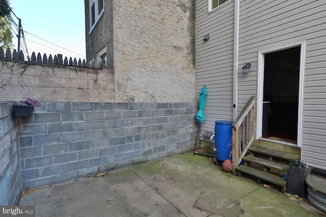 view of property exterior with entry steps, a patio, and fence
