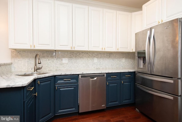 kitchen with a sink, blue cabinets, dark wood finished floors, and appliances with stainless steel finishes