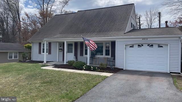cape cod home with covered porch, aphalt driveway, an attached garage, a front lawn, and a shingled roof