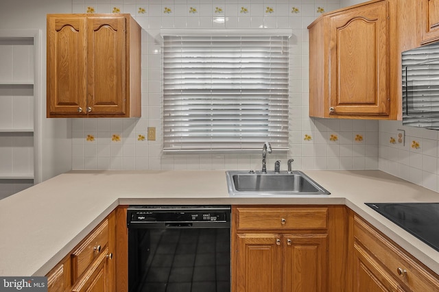 kitchen featuring black appliances, light countertops, a sink, and backsplash