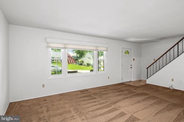 carpeted entryway featuring stairway