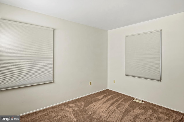 unfurnished room featuring carpet floors and baseboards