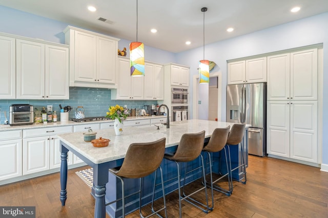 23593 Robalo Rd, Frankford, DE 19945 - kitchen with appliances with stainless steel finishes, tasteful backsplash, a kitchen bar, white cabinets, and recessed lighting