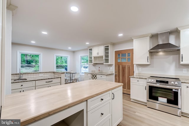 6488 Davis Ford Rd, Manassas, VA 20111 - kitchen with stainless steel range with electric cooktop, wall chimney range hood, light wood finished floors, white cabinets, and recessed lighting
