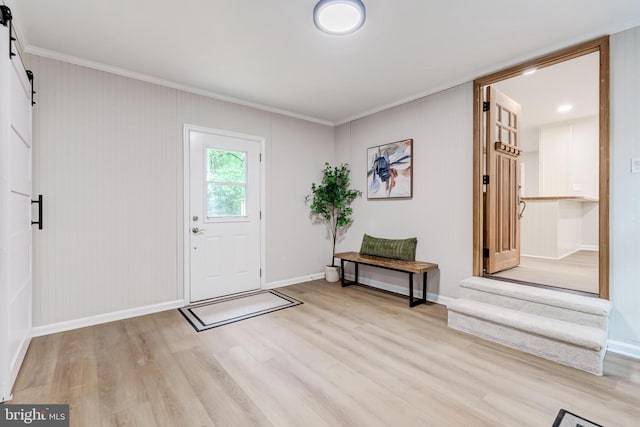 6488 Davis Ford Rd, Manassas, VA 20111 - entryway featuring a barn door, ornamental molding, light wood finished floors, and baseboards