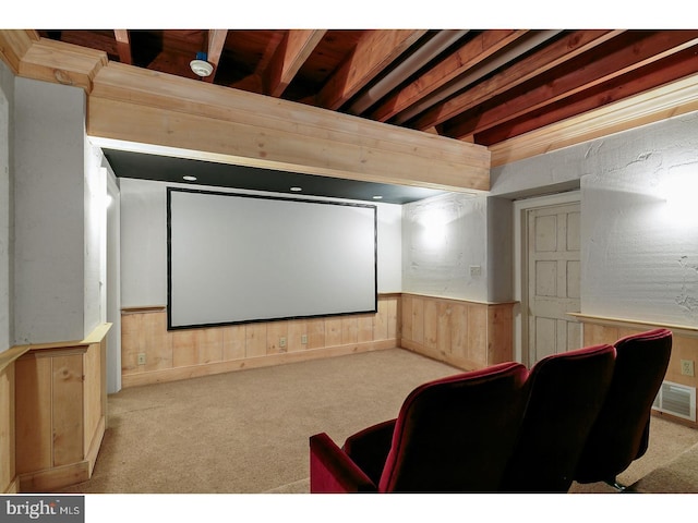 cinema room featuring wooden walls, wainscoting, and carpet floors