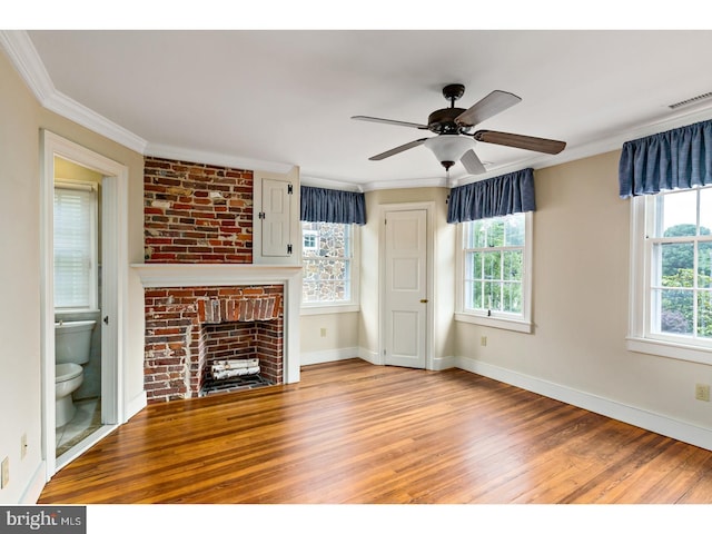 unfurnished living room with a ceiling fan, baseboards, ornamental molding, wood finished floors, and a fireplace