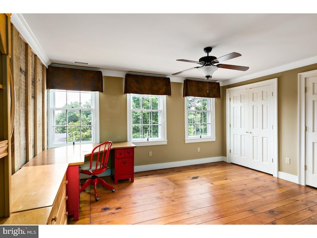 home office with crown molding, light wood-type flooring, baseboards, and a ceiling fan