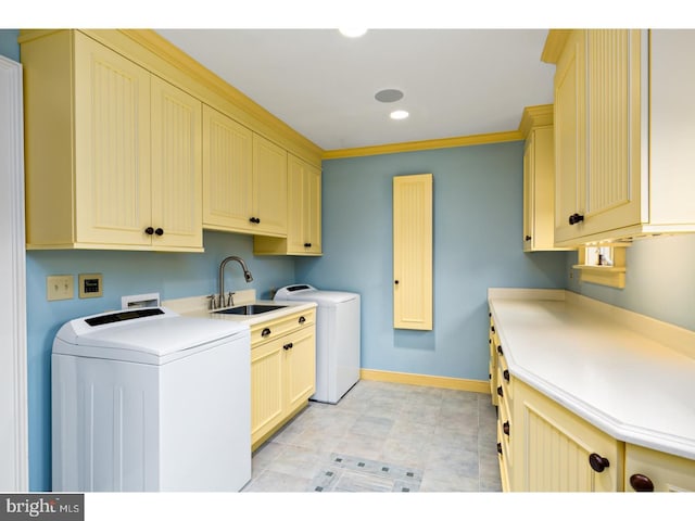 laundry room featuring a sink, washer / clothes dryer, cabinet space, and baseboards