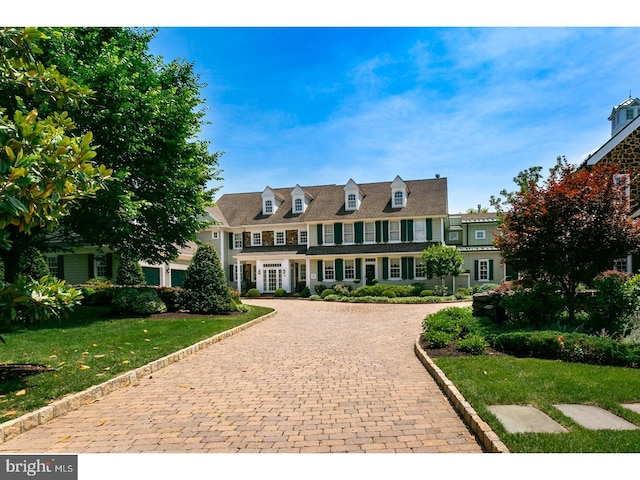 view of front of property with a front yard and curved driveway