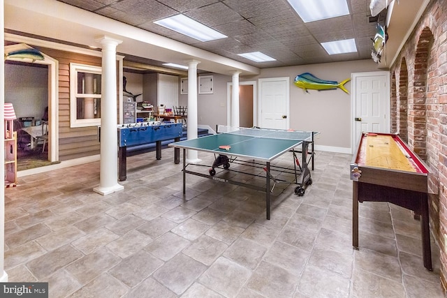 recreation room featuring baseboards and ornate columns