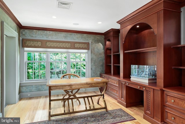 interior space with ornamental molding, light wood finished floors, visible vents, and built in desk